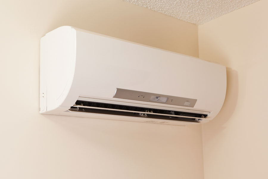 Wall-mounted split air conditioning unit in a room