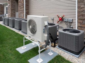 Air conditioning units lined up outside a building on a gravel bed