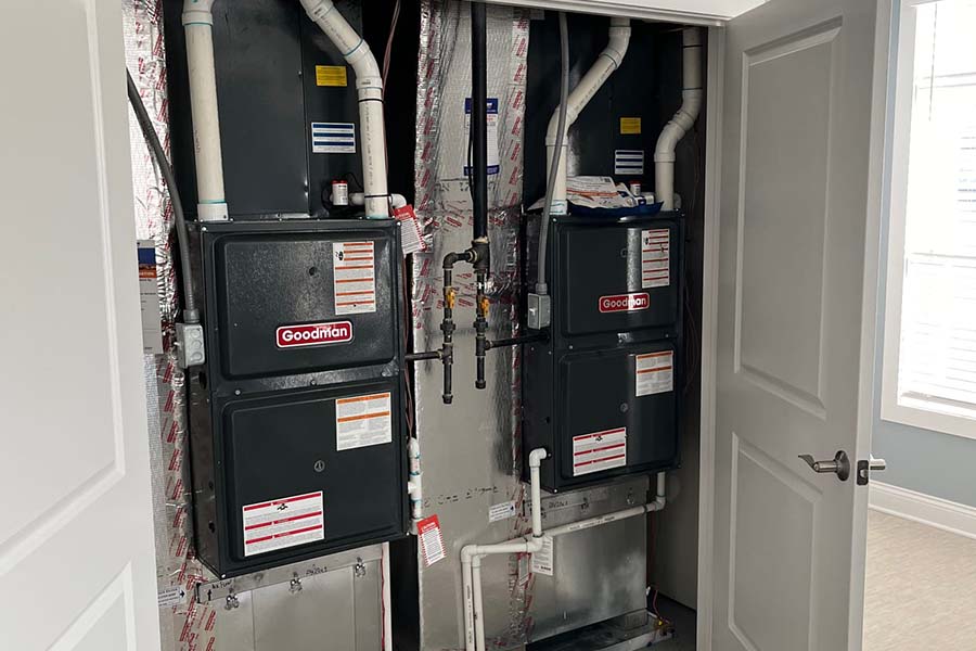 Dual Goodman HVAC furnaces in a utility closet.