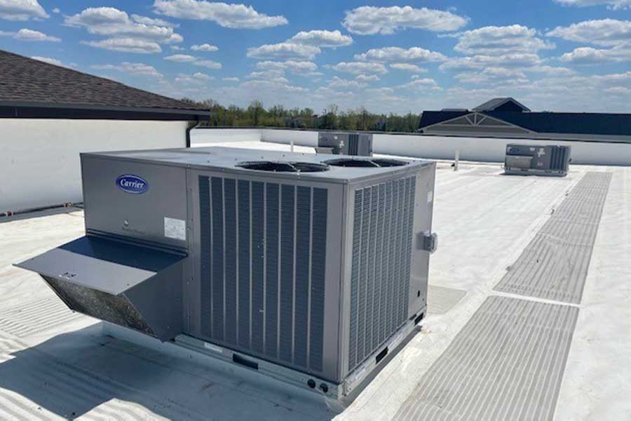 Carrier rooftop HVAC units installed on a commercial building under a blue sky